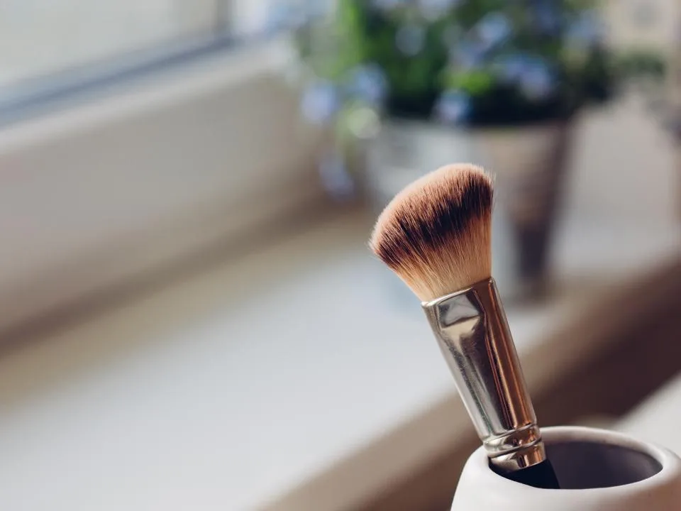 A makeup brush on a sunny window sill