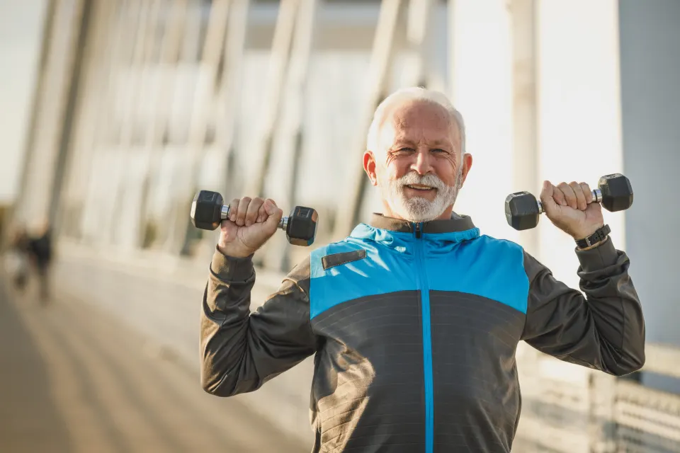 An older man lifting dumbbells