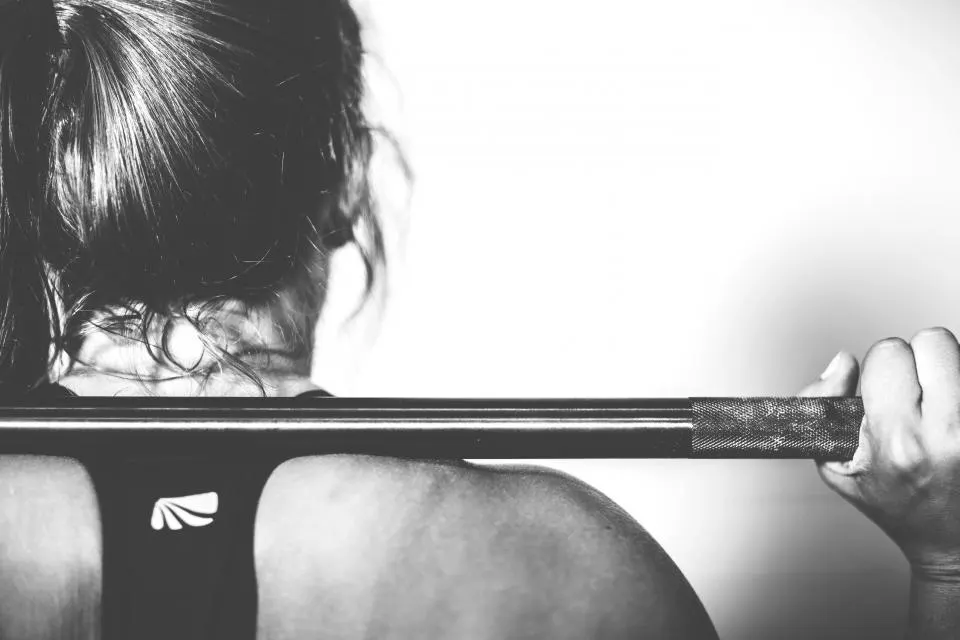 A woman gripping a barbell before a lift
